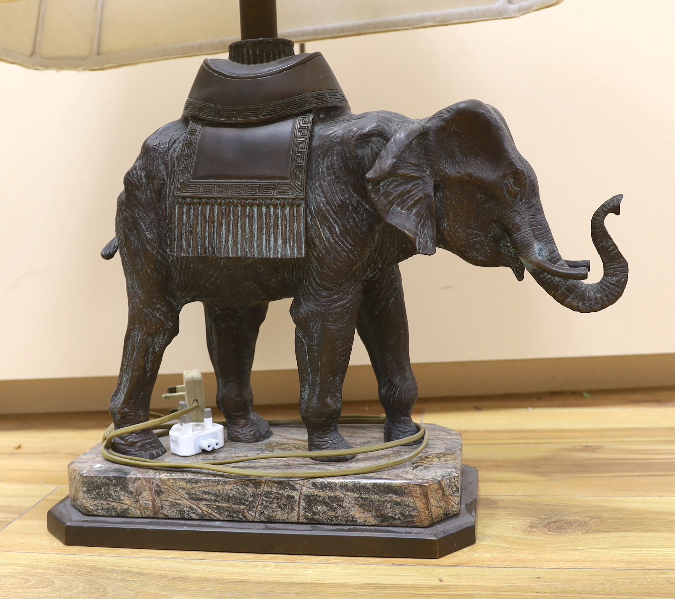 A bronzed elephant table lamp raised on shaped base, with shade, 79cm high